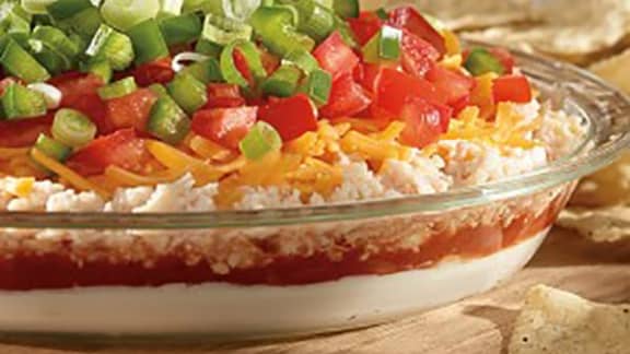 Entrée étagée de fromage à la crème et crème sûre, légumes, salsa et fromage