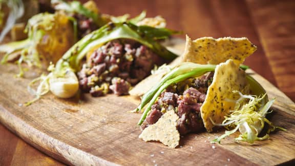 Tartare de mi-cuit de canard, olives, oignons verts grillés et tuiles de chanvre à l'estragon