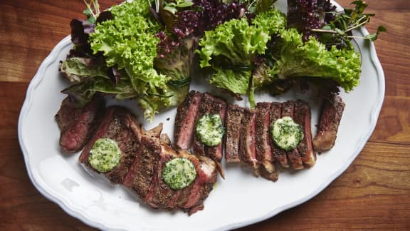 Steak de contre filet et son beurre composé aux herbes fraiches, servi avec un bouquet de jeune laitue et sa vinaigrette