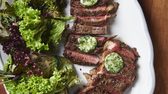 Steak de contre filet et son beurre composé aux herbes fraiches, servi avec un bouquet de jeune laitue et sa vinaigrette