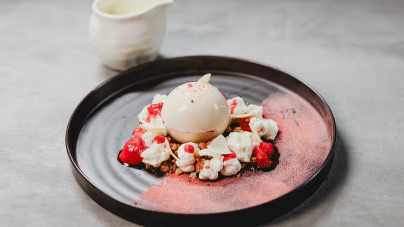 Sphère de chocolat au riz au lait, compotée de fraises et rhubarbe, crumble de pistaches