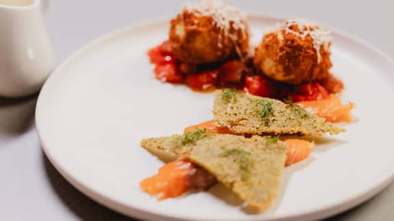 Œufs en panure, tomates confites, saumon, tuiles aux herbes et hollandaise