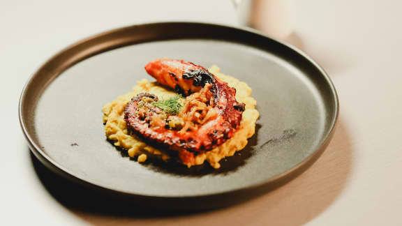 Pieuvre grillée, fava, sauce aux câpres, tomates et oignons frits