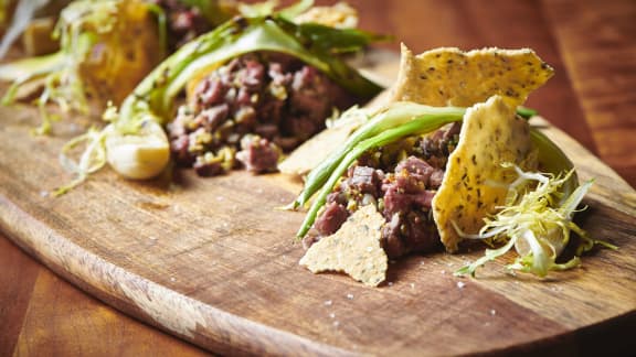 Tartare de mi-cuit de canard, olives, oignons verts grillés et tuiles de chanvre à l'estragon