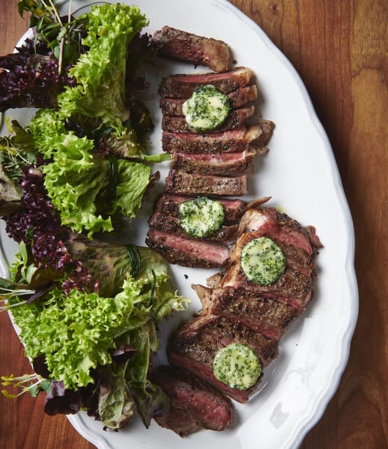 Steak de contre filet et son beurre composé aux herbes fraiches, servi avec un bouquet de jeune laitue et sa vinaigrette