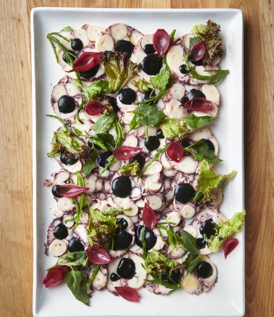 Carpaccio de pieuvre, oignons marinés, mayo à l’encre de seiche et petites verdures des mers