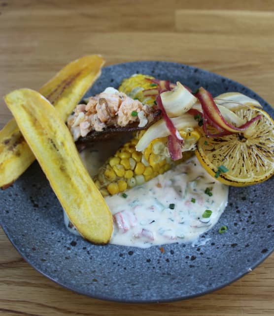 Truite grillée, maïs boucané, chips de plantain et peau de poisson croustillante
