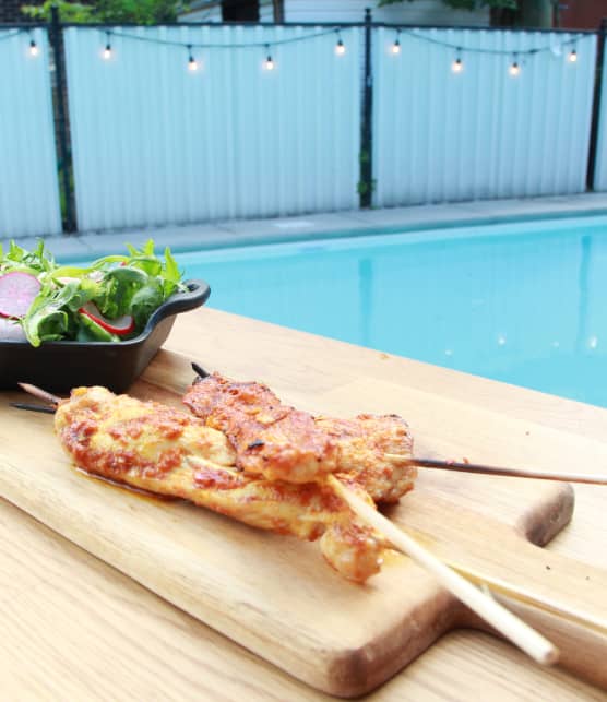 Brochettes de poulet au cari rouge, salade verte et radis marinés