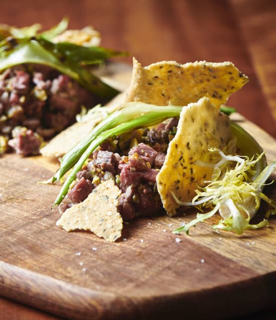 Tartare de mi-cuit de canard, olives, oignons verts grillés et tuiles de chanvre à l'estragon