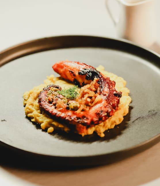 Pieuvre grillée, fava, sauce aux câpres, tomates et oignons frits